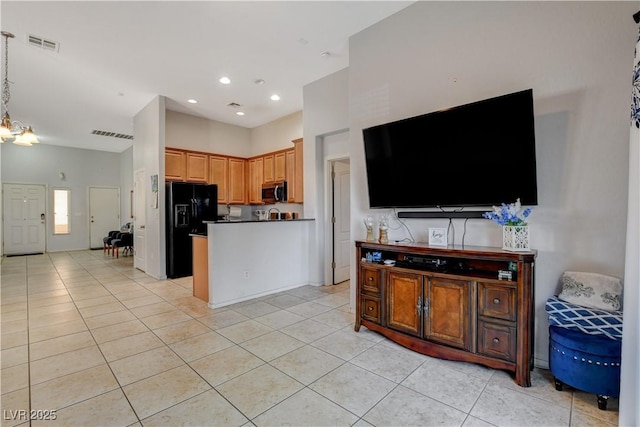 kitchen featuring light tile patterned floors, black fridge with ice dispenser, and an inviting chandelier