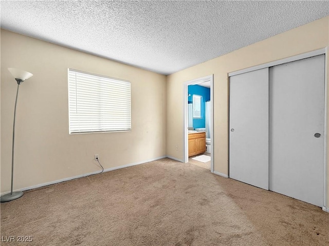 3350 Stacey Lyn Dr, Las Vegas, NV 89117 - unfurnished bedroom featuring a textured ceiling, ensuite bathroom, a closet, and light carpet