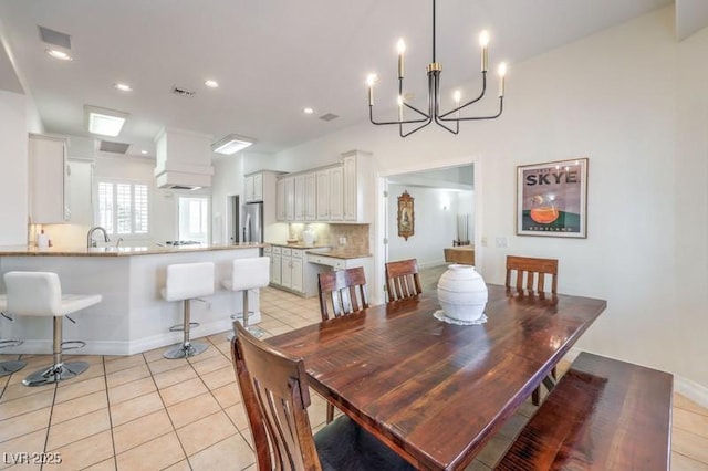 dining space with an inviting chandelier, light tile patterned floors, and sink