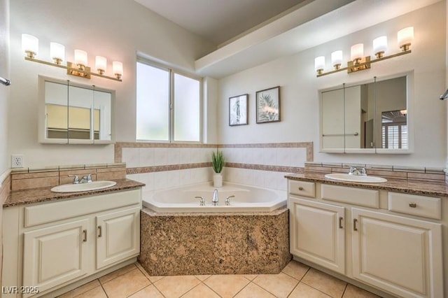 bathroom with tile patterned floors, tiled tub, and vanity