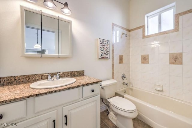 full bathroom featuring toilet, tiled shower / bath, and vanity