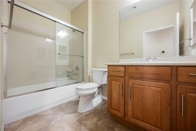 full bathroom featuring vanity, tile patterned flooring, toilet, and combined bath / shower with glass door