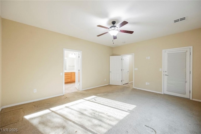 unfurnished bedroom with a closet, ceiling fan, light carpet, and ensuite bath