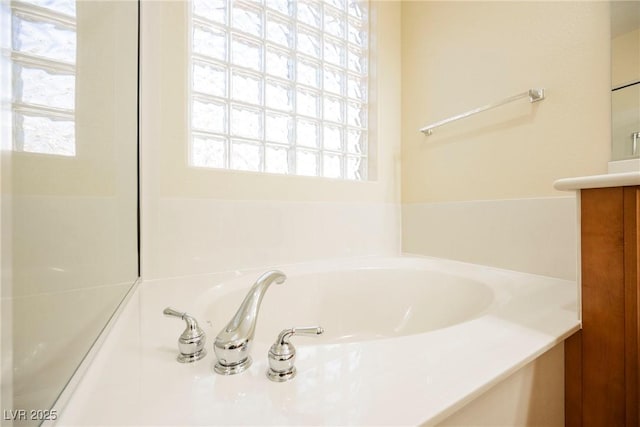 bathroom with vanity and a washtub