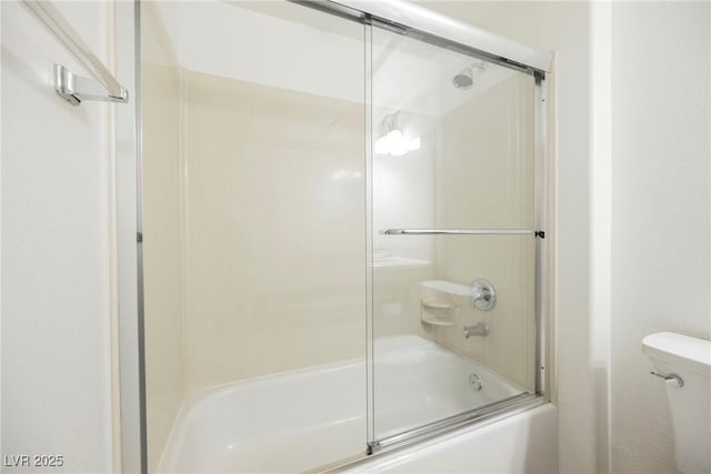 bathroom with bath / shower combo with glass door and toilet