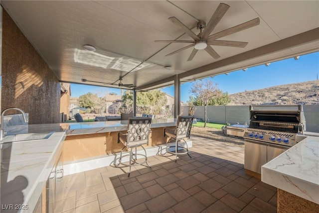 view of patio / terrace with ceiling fan, a mountain view, and a wet bar