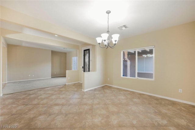 unfurnished room featuring a notable chandelier