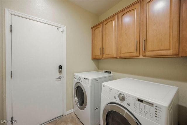 washroom featuring cabinets, light tile patterned floors, and washer and clothes dryer