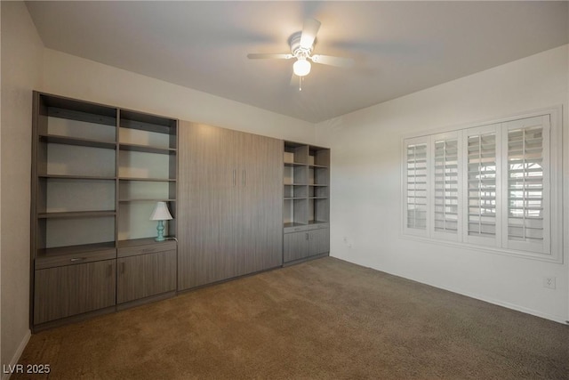 unfurnished bedroom with ceiling fan and dark colored carpet