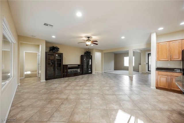 unfurnished living room with ceiling fan and light tile patterned floors