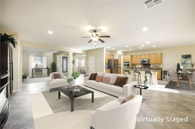 living room featuring light tile patterned floors and ceiling fan