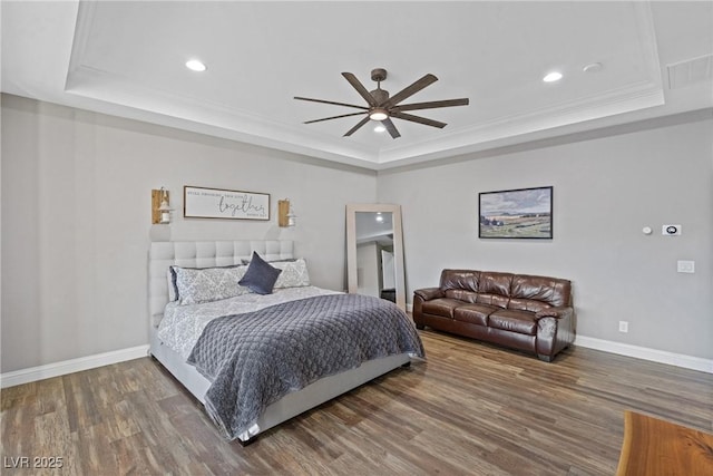 bedroom with a raised ceiling, ceiling fan, and dark hardwood / wood-style flooring