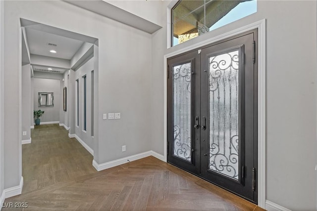 entryway featuring vaulted ceiling, french doors, and parquet flooring