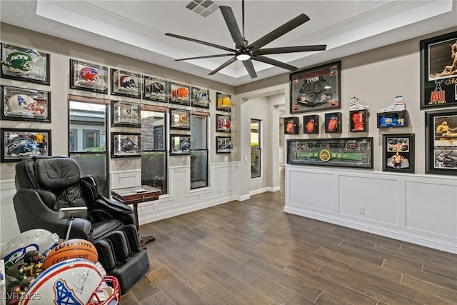 sitting room with ceiling fan, dark hardwood / wood-style flooring, and a raised ceiling