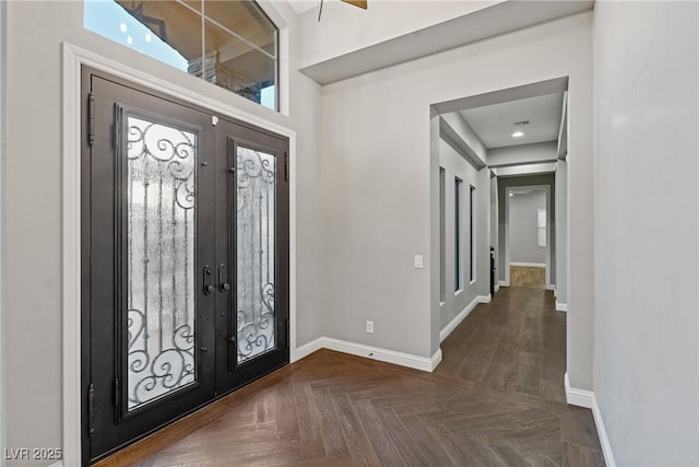 entrance foyer featuring plenty of natural light, dark parquet flooring, and french doors