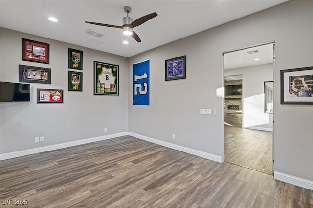 empty room with ceiling fan and hardwood / wood-style floors