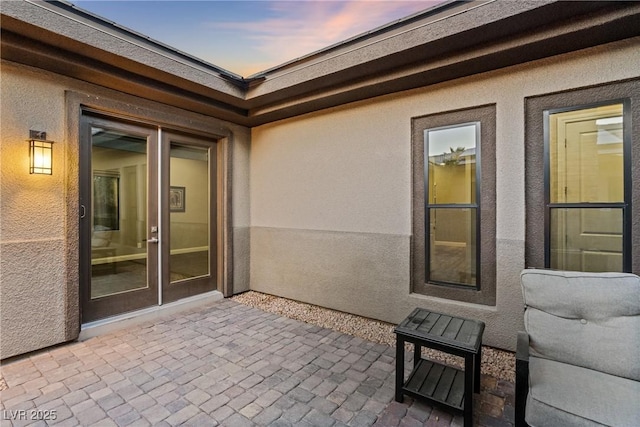 patio terrace at dusk featuring french doors