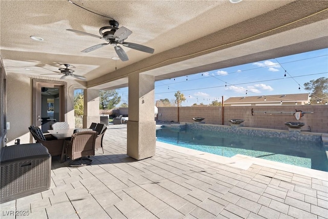 view of patio with ceiling fan and a fenced in pool