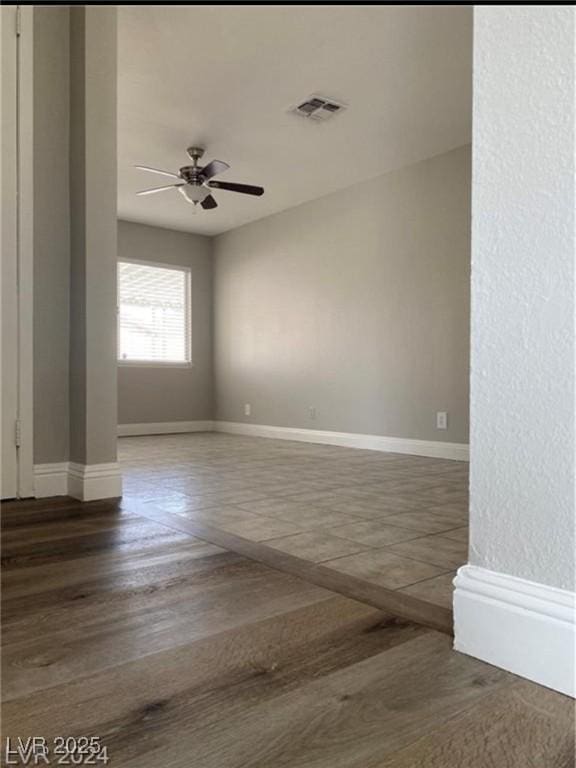 empty room featuring ceiling fan and dark hardwood / wood-style flooring