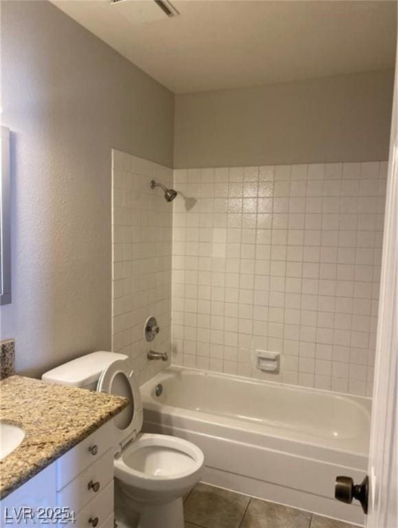 full bathroom featuring toilet, tile patterned flooring, tiled shower / bath, and vanity