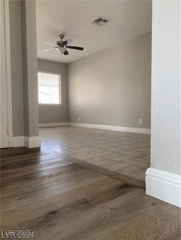 empty room with ceiling fan and dark hardwood / wood-style floors