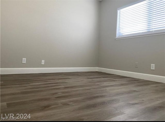 empty room with dark hardwood / wood-style flooring