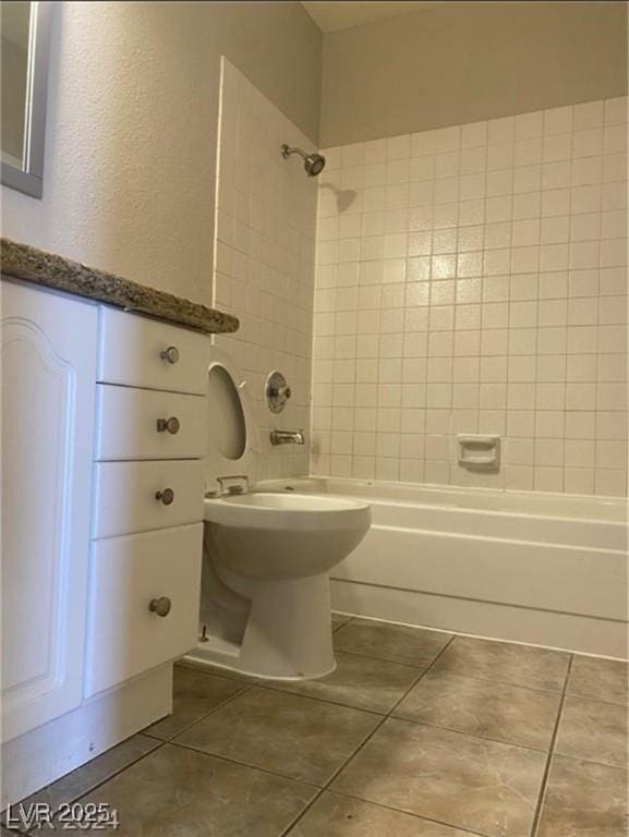 bathroom featuring tile patterned flooring and tiled shower / bath