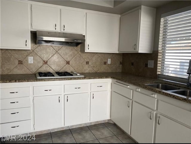 kitchen with white cabinetry, white gas stovetop, and tasteful backsplash