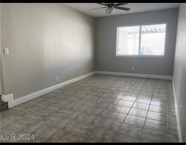 tiled empty room featuring ceiling fan