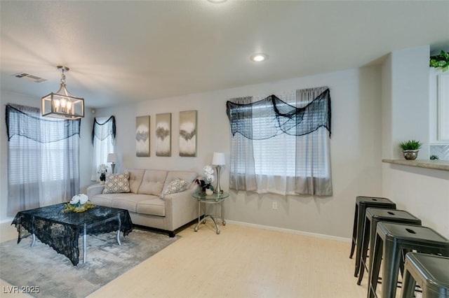 living room with wood-type flooring and an inviting chandelier