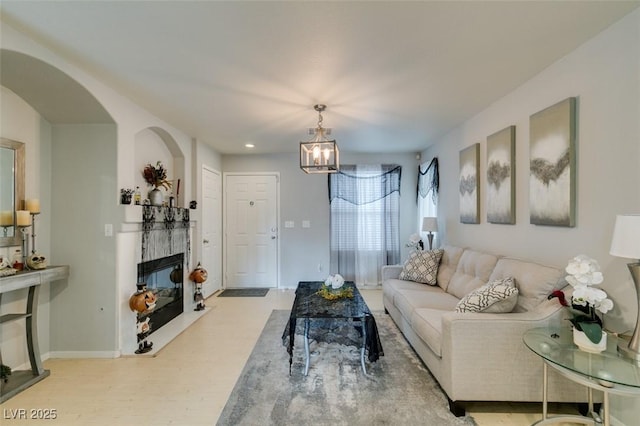 living room featuring a high end fireplace, an inviting chandelier, and light hardwood / wood-style floors