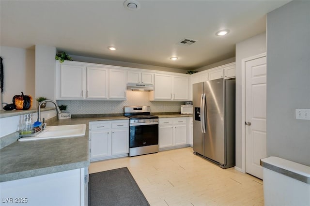 kitchen with stainless steel appliances, white cabinets, tasteful backsplash, and sink