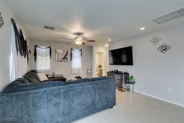 living room with ceiling fan and light hardwood / wood-style flooring