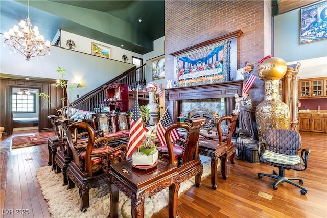 interior space featuring high vaulted ceiling, wood-type flooring, and an inviting chandelier