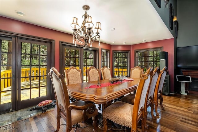 dining room with dark hardwood / wood-style floors and a chandelier