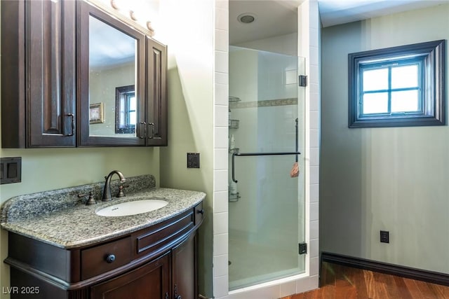 bathroom with an enclosed shower, vanity, and hardwood / wood-style floors