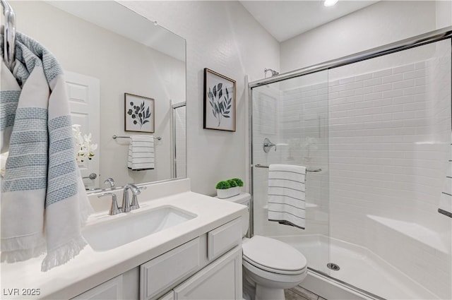 bathroom featuring toilet, walk in shower, and vanity