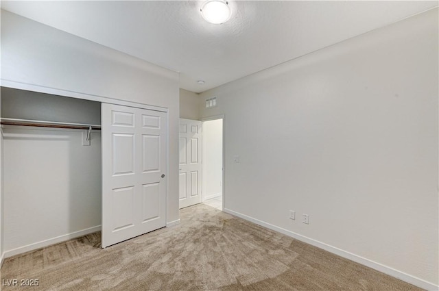 unfurnished bedroom featuring a closet and light carpet