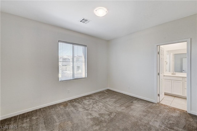 unfurnished room with light carpet and sink