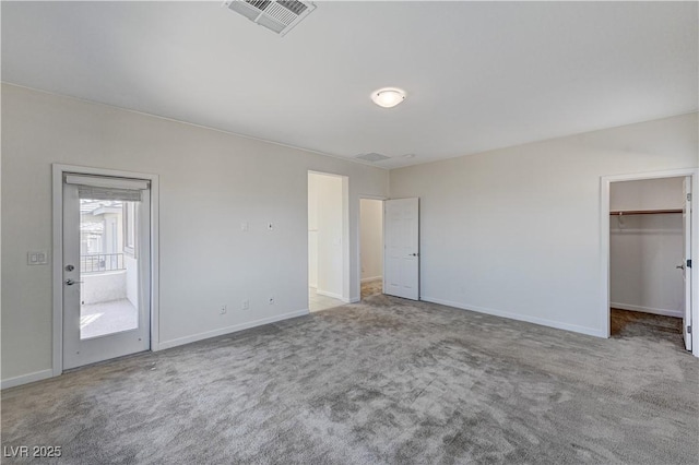 unfurnished bedroom featuring carpet floors, a closet, and a walk in closet