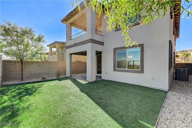 back of house with a balcony, central AC unit, and a lawn