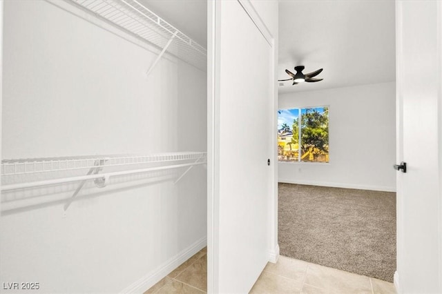 spacious closet with ceiling fan and light carpet