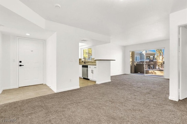 unfurnished living room featuring light colored carpet and sink