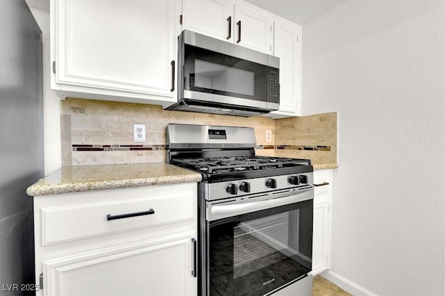 kitchen with white cabinetry, stainless steel appliances, and backsplash