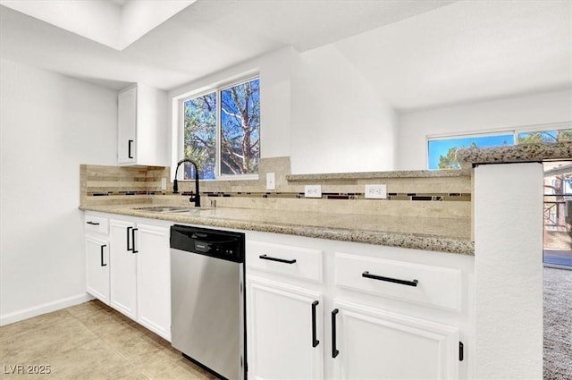 kitchen featuring white cabinetry, stainless steel dishwasher, plenty of natural light, and sink