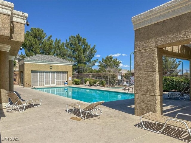 view of swimming pool with an outdoor structure and a patio