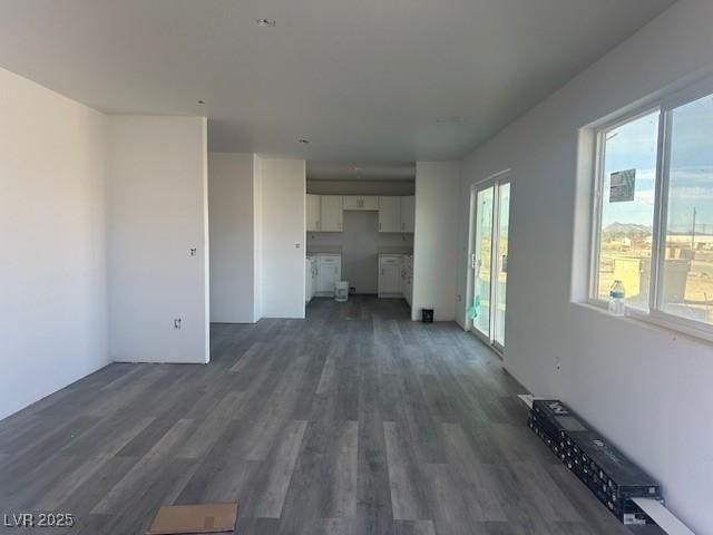 unfurnished living room featuring dark hardwood / wood-style flooring and plenty of natural light