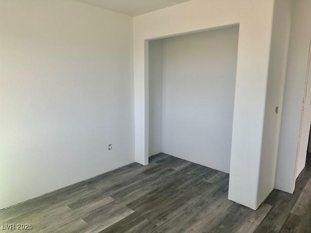 unfurnished room featuring dark wood-type flooring