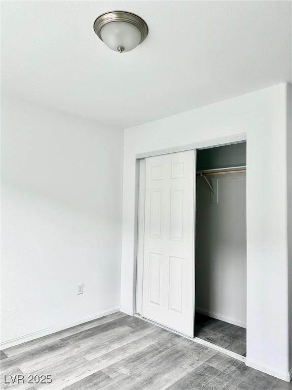 unfurnished bedroom with a closet and wood finished floors