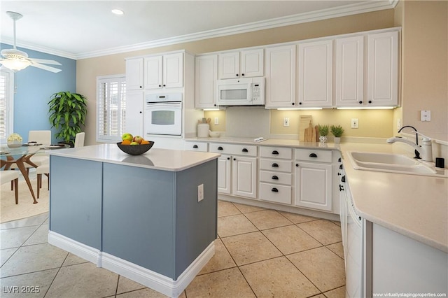 kitchen with ceiling fan, sink, crown molding, white appliances, and white cabinetry